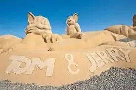 Sand City Museum showcases a detailed sand sculpture of two animals, reflecting mythological and Disney themes in an open-air setting.