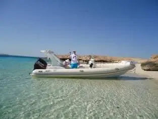 Man on a boat in open water, showcasing the journey to Orange Bay Island with a private speedboat adventure on the Red Sea.