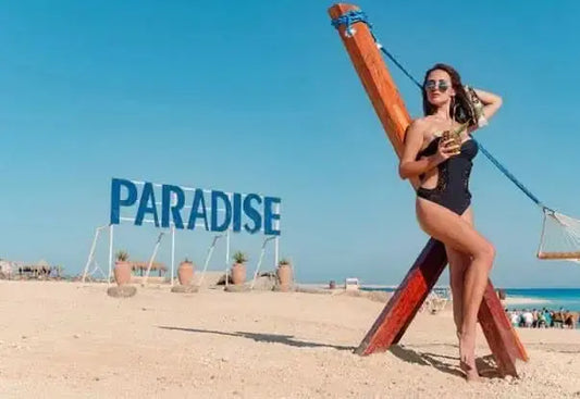 Woman in a black swimsuit on a beach, representing the Paradise Island private speedboat and snorkeling tour experience.
