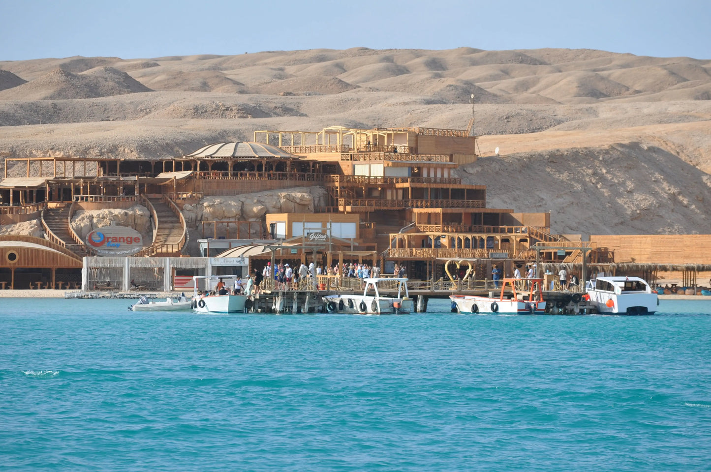 Orange Bay Tour: Boats on serene waters near a scenic building, capturing the adventure and relaxation essence of the Hurghada excursion.