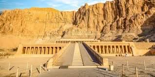 Day trip to Luxor: Stone walkway leading to Karnak Temple's large rock formations, highlighting this historic Egyptian site's grandeur and cultural significance.