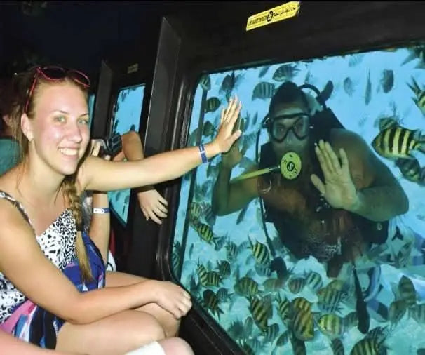 A man in scuba gear exploring the underwater world, highlighting the Royal Sea Scope glass bottom boat experience in Hurghada.