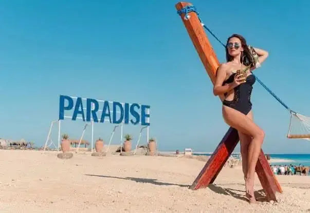 Woman in a black swimsuit on a beach, representing the Paradise Island private speedboat and snorkeling tour experience.