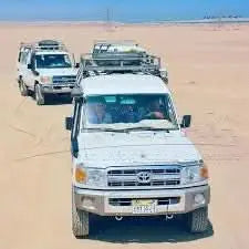 Jeep-Safari with Stargazing: A convoy of vehicles traverses a desert landscape, showcasing the adventure's rugged terrain and exploration spirit.