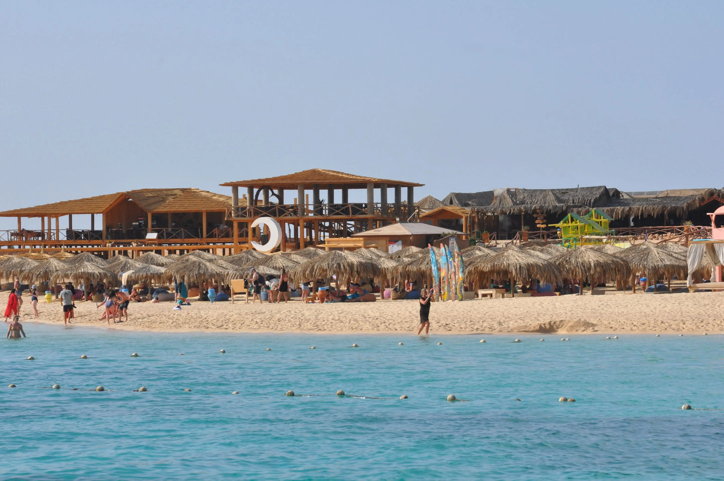 Orange Bay Tour: A vibrant beach scene with people enjoying the shore, highlighting the adventure and relaxation offered in Hurghada.
