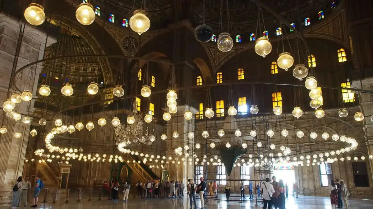 People exploring a grand, illuminated indoor space, symbolizing the immersive experience of the Cultural Tour to Cairo - 1 day, highlighting cultural and historical exploration.