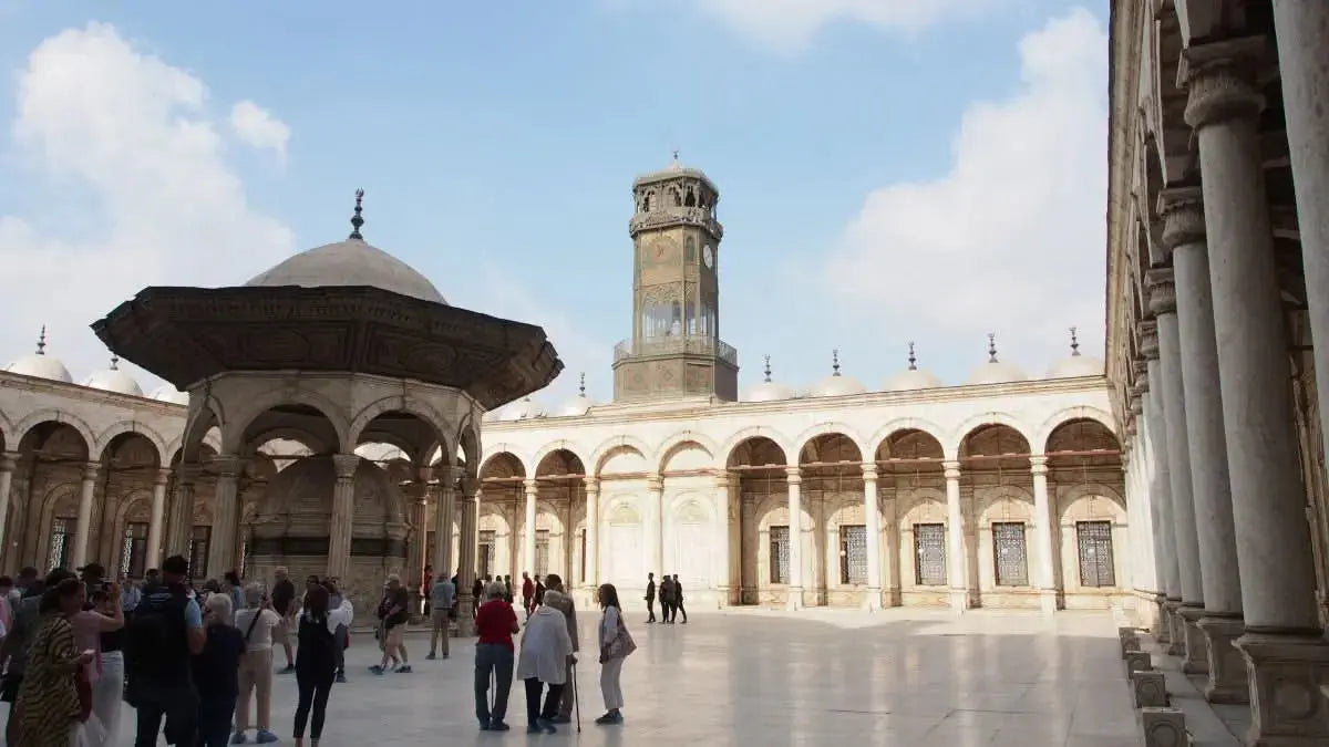 Tourists gather near a historic clock tower, symbolic of the Cultural Tour to Cairo - 1 day, highlighting Egypt's architectural wonders.