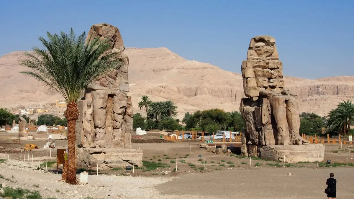 Luxor tour includes stone statues in a desert landscape, highlighting ancient Egyptian history and landmarks like the Karnak Temple and Memnon Colossi.