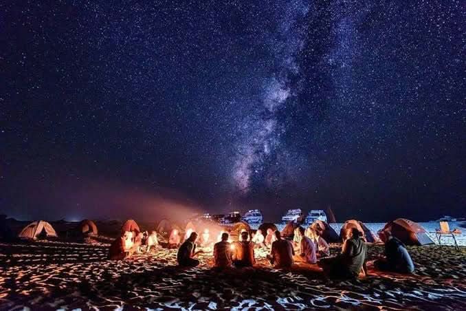 People enjoying a campfire under a starry sky during the jeep safari with stargazing, highlighting the adventure's blend of nature and astronomy experiences.