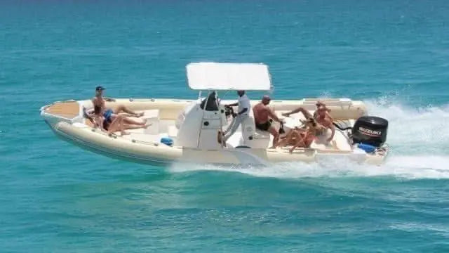 Private speedboat with passengers on a serene sea journey to Orange Bay Island, showcasing a relaxing adventure on the Red Sea waters.