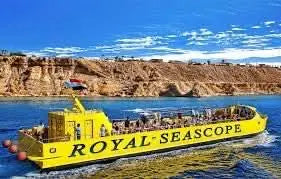 Royal Sea Scope - лодка со стеклянным дном на воде с людьми, наслаждающимися живописным приключением, с панорамным видом на яркий подводный мир Красного моря.