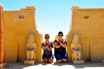Mini Egypt Park features a couple posing near historical statues, offering a unique, educational experience of Egypt's attractions in a charming outdoor setting.