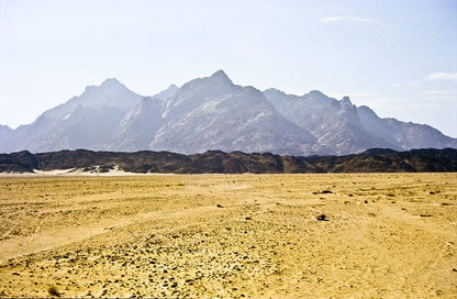 Day trip to Luxor: Scenic desert landscape with distant mountains, capturing the essence of the journey's natural beauty and historical allure.