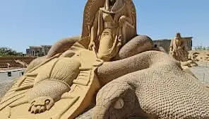 Statue of a woman sitting on a snake, showcasing the artistic charm of Mini Egypt Park's unique miniature sculpture collection.
