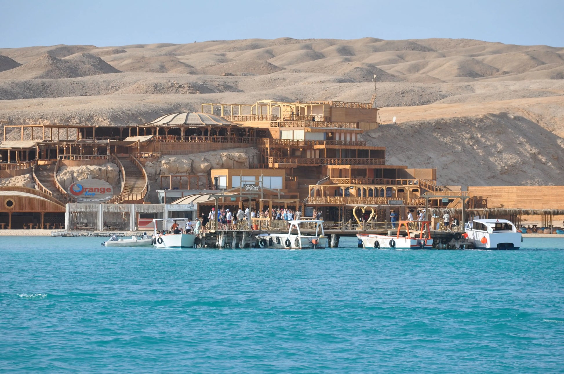 Orange Bay Tour: Boats on serene waters near a scenic building, capturing the adventure and relaxation essence of the Hurghada excursion.