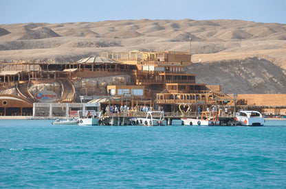 Orange Bay Tour: Boats on serene waters near a scenic building, capturing the adventure and relaxation essence of the Hurghada excursion.
