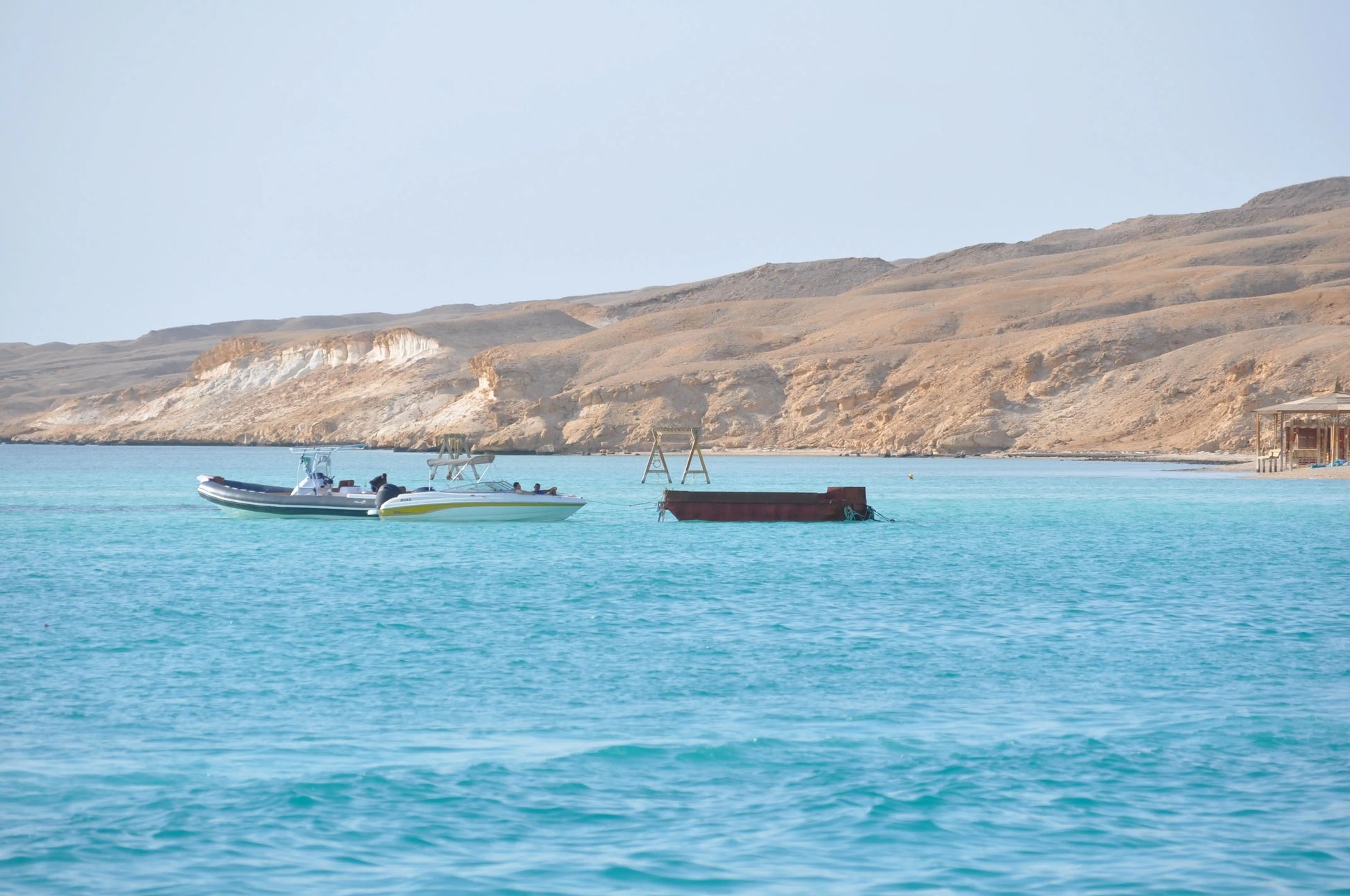 Boat on water with a person onboard, depicting the Orange Bay Tour experience in Hurghada, featuring snorkeling, sandy beaches, and a delicious onboard lunch.