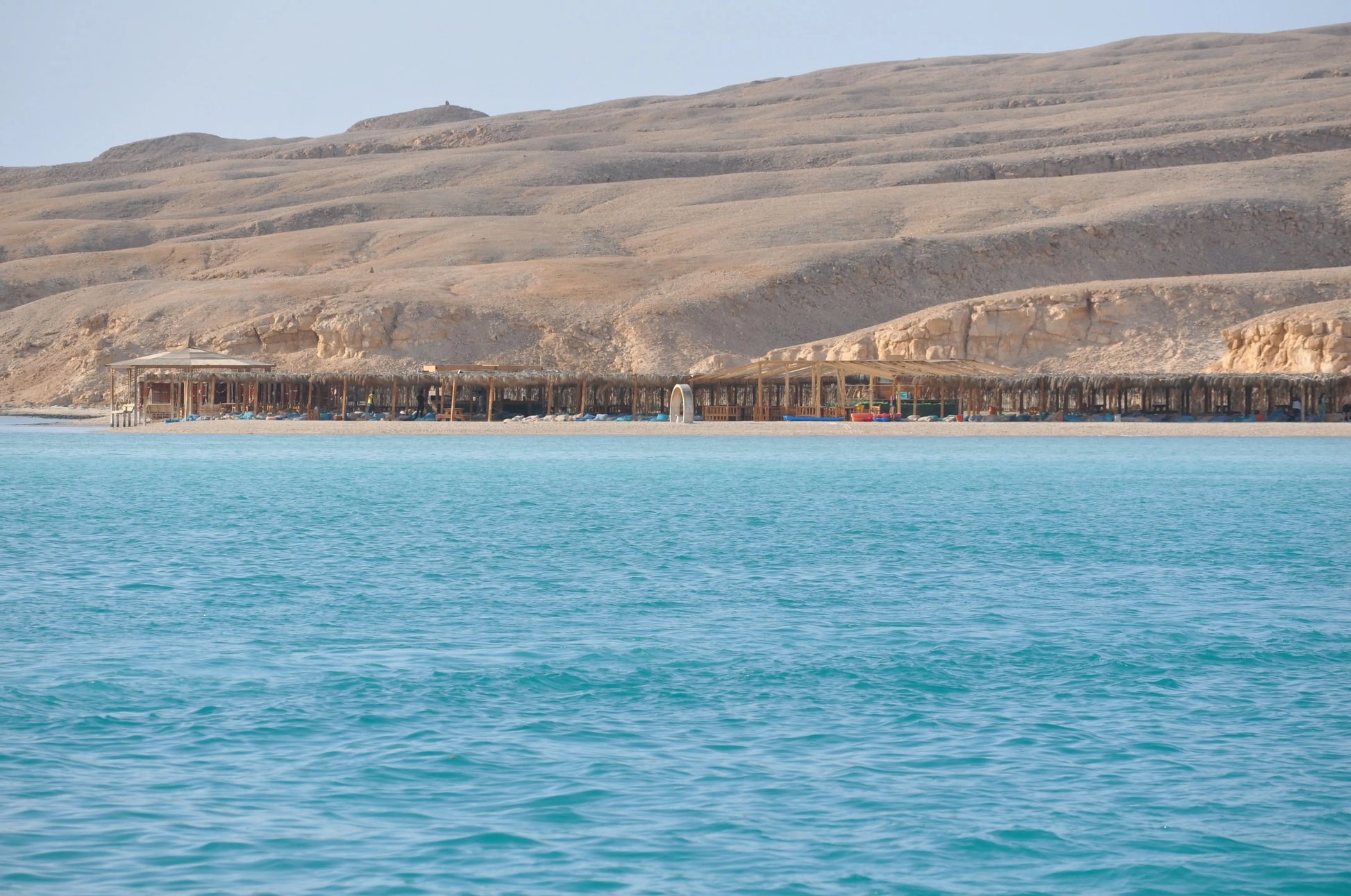 Orange Bay Tour: A scenic image of a serene beach with a wooden structure, showcasing the tranquil setting for a day of adventure and relaxation in Hurghada.
