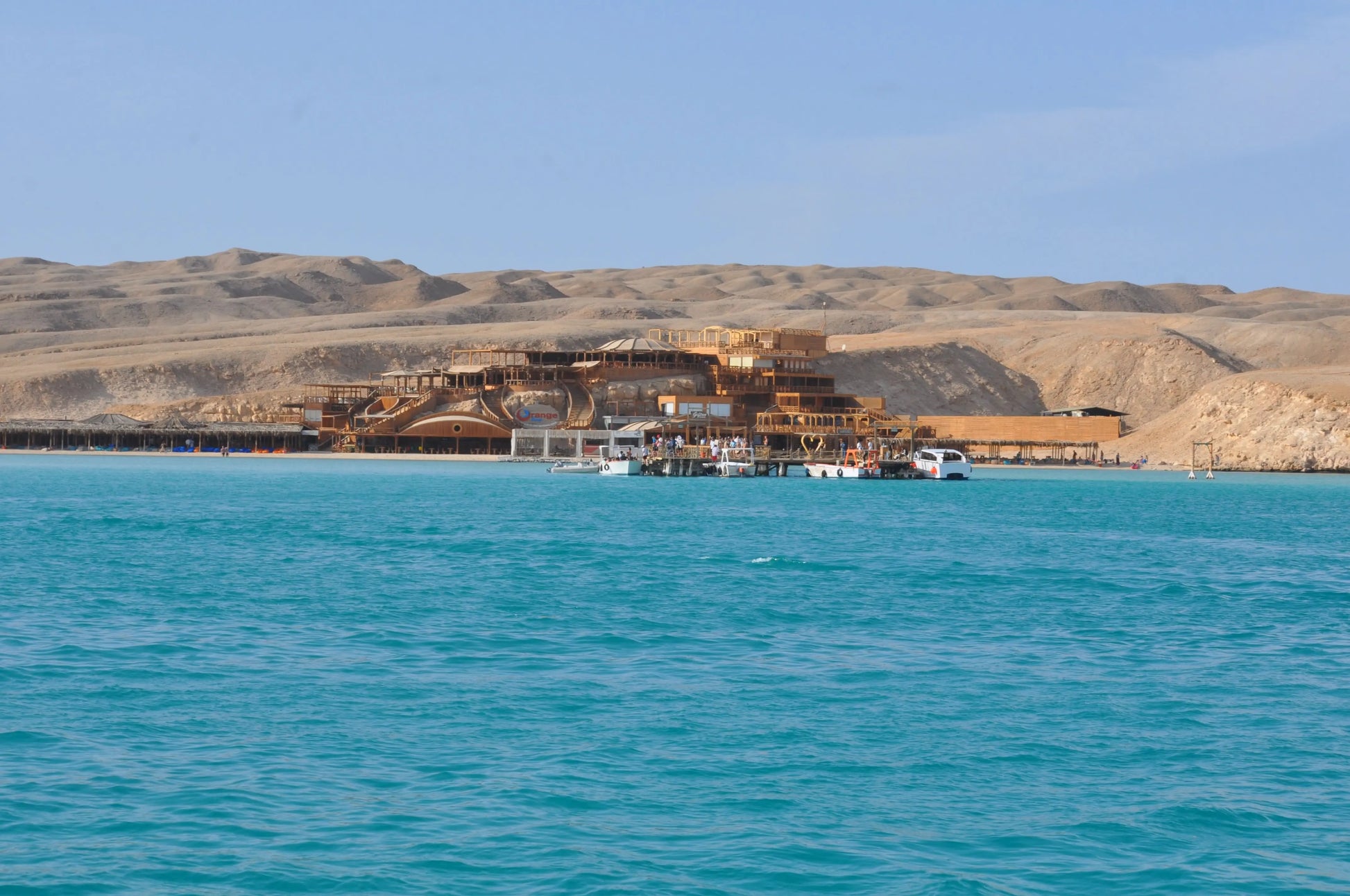 Orange Bay Tour: A scenic view of a building by the water with a dock, highlighting the adventure and relaxation awaiting in Hurghada.
