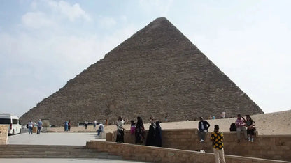 Tourists stand before the Giza Pyramids, part of the Cultural Tour to Cairo - 1 day, showcasing Egypt's historic wonders and architectural marvels.