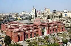 Cultural tour to Cairo - 1 day: Cityscape with iconic red dome building and palm trees, symbolizing historical exploration of Egypt, including Giza Pyramids tour.